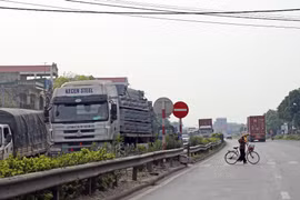 Lưu lượng xe đông, đường xuống cấp và hệ thống đường gom, cầu vượt chưa được thiết kế đầy đủ là những nguy hiểm rình rập với người đi trên Quốc lộ 5. (Ảnh: Huy Hùng/Vietnam+)