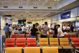 Nhân viên an ninh hàng không kiểm tra, giám sát hành khách tại khu vực làm thủ tục bay. (Ảnh: Việt Hùng/Vietnam+)