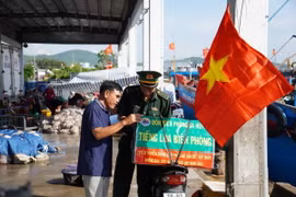 Các chiến sỹ biên phòng cùng với xe gắn máy và chiếc loa kéo mini di chuyển khắp các cảng cá, bến bãi, khu dân cư để tuyên truyền pháp luật. (Ảnh: TTXVN phát)