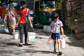 Các em nhỏ lấy nước tại điểm cấp nước công cộng ở New Delhi, Ấn Độ. (Ảnh: AFP/TTXVN)