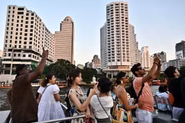 Khách du lịch đi thuyền trên sông Chao Praya ở Bangkok, Thái Lan. (Ảnh: AFP/TTXVN)