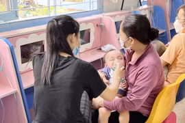Một bệnh nhi đang được người nhà xông khí dung. (Ảnh: Đinh Hằng/TTXVN)