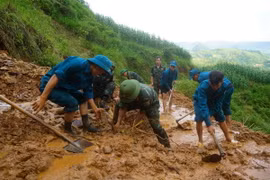 Cán bộ, chiến sỹ Ban Chỉ huy Quân sự huyện Mèo Vạc cùng lực lượng dân quân khơi thông tuyến đường vào thôn Khuổi Roài, xã Tát Ngà bị cô lập do mưa lũ. (Ảnh: Hà Linh/TTXVN phát)