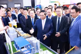 Thủ tướng Phạm Minh Chính tham quan gian trưng bày các sản phẩm ứng dụng khoa học và công nghệ. (Ảnh: Dương Giang/TTXVN)