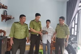 Anh Lê Nhật Hoàng bàn giao cá thể tê tê cho Hạt kiểm lâm Châu Đức-Bà Rịa. (Ảnh: Hoàng Nhị/TTXVN)