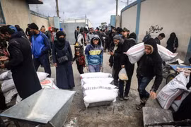 Người tị nạn Palestine nhận lương thực cứu trợ tại thành phố Rafah, Dải Gaza. (Ảnh: AFP/TTXVN)