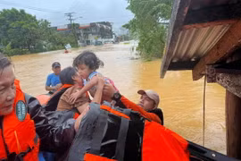 Lực lượng cứu hộ sơ tán em nhỏ khỏi vùng ngập lụt tại thị trấn Catarman, Philippines,. (Ảnh minh họa. AFP/TTXVN)
