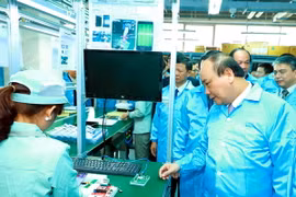 Thủ tướng Nguyễn Xuân Phúc thăm khu sản xuất của Công ty cổ phần Công nghệ công nghiệp Bưu chính viễn thông Việt Nam. (Ảnh: Thống Nhất/TTXVN)
