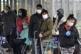 Người dân xếp hàng nhận lương thực cứu trợ tại New York, Mỹ. (Ảnh: AFP/TTXVN)