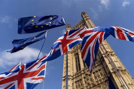 Quốc kỳ Anh (dưới) và cờ Liên minh châu Âu (EU) bên ngoài tòa nhà Quốc hội Anh ở Westminster, London. (Ảnh: AFP/TTXVN)
