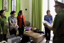 Cơ quan công an đọc lệnh bắt Nguyễn Thị Huyền Trang-áo xám. (Nguồn: vov.vn)