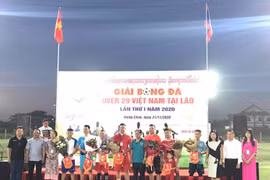 Đại diện Đại sứ quán Việt Nam tại Lào cùng các đại biểu tặng hoa và cờ lưu niệm cho tổ trọng tài và 7 đội tham dự giải. (Ảnh: Thu Phương/TTXVN)