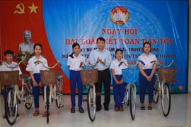 Ông Nguyễn Đức Lợi, Ủy viên Trung ương Đảng, Tổng Giám đốc TTXVN, trao xe đạp cho các em học sinh ở xã Triệu Trung. (Ảnh: Hồ Cầu/TTXVN)