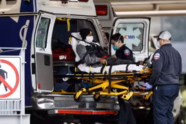 Nhân viên y tế chuyển bệnh nhân COVID-19 tới bệnh viện tại Washington D.C., Mỹ. (Ảnh: THX/TTXVN)