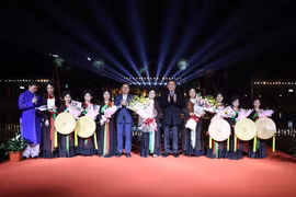 Chủ tịch Quốc hội Vương Đình Huệ tặng hoa chúc mừng các nghệ nhân quan họ và thiếu nhi tham gia biểu diễn dân ca quan họ Bắc Ninh. (Ảnh: Thanh Thương/TTXVN)