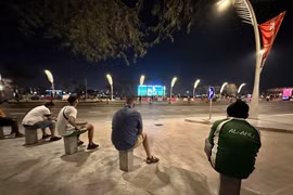 Những người lao động nhập cư đang xem World Cup từ vỉa hè. (Nguồn: Thể thao và Văn hóa)