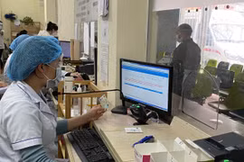 Làm thủ tục cho bệnh nhân đến khám, chữa bệnh bảo hiểm y tế bằng căn cước công dân. (Nguồn: Vietnam+)