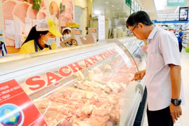 Người tiêu dùng mua thịt lợn tại siêu thị coopmart. (Ảnh: Đỗ Phương Anh/TTXVN)