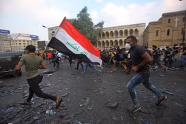 Người biểu tình Iraq tại cây cầu al-Jumhuriya dẫn đến Vùng Xanh, nơi được bảo vệ nghiêm ngặt ở thủ đô Baghdad. (Ảnh: AFP/TTXVN)