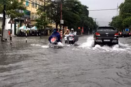 Nhiều tuyến đường thành phố Vinh bị ngập khiến các phương tiện tham gia giao thông gặp nhiều khó khăn. (Ảnh: Tá Chuyên/TTXVN)
