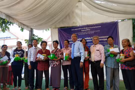 Ông Trần Đức Hiển, Phó Chủ nhiệm Ủy ban về người Việt Nam ở nước ngoài Thành phố Hồ Chí Minh cùng đại diện đoàn trao quà cho bà con. (Ảnh: Minh Hưng/TTXVN)
