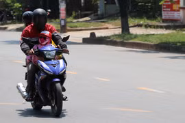 Người dân thành phố Đông Hà ra đường với ''trang phục'' kín mít để tránh nắng nóng. (Ảnh: Nguyên Lý/TTXVN)