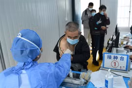Nhân viên y tế tiêm vaccine ngừa COVID-19 cho người dân tại tỉnh Chiết Giang (Trung Quốc), hồi tháng 12 năm ngoái. (Ảnh: AFP/TTXVN)