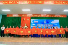 Đại diện lãnh đạo tỉnh Thanh Hóa và báo Người lao động tặng cờ tổ quốc cho người dân. Ảnh: Trịnh Duy Hưng - TTXVN