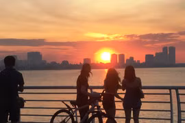 Các bạn trẻ ngắm hoàng hôn bên Hồ Tây (Hà Nội), lúc nhiệt độ trong ngày dịu dần. (Ảnh: Ngọc Duy)