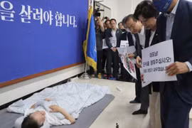 Các nhà lập pháp kêu gọi ông Lee Jae-myung (nằm trên sàn) chấm dứt tuyệt thực. (Ảnh: Yonhap/The Korea Herald)