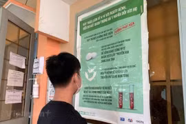 Một bạn trẻ đọc thông tin tuyên truyền về phòng chống HIV/AIDS và công tác điều trị. (Ảnh: T.G/Vietnam+)