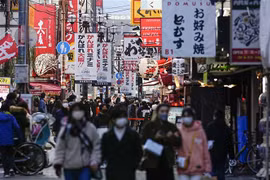 Người dân đeo khẩu trang phòng dịch COVID-19 khi đi trên đường phố tại Osaka (Nhật Bản). (Ảnh: Kyodo/TTXVN)