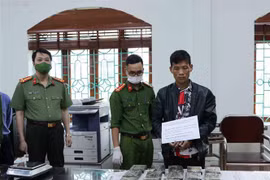 Đối tượng Giàng A Páo cùng tang vật tại cơ quan điều tra. (Ảnh: Đinh Thùy/TTXVN)
