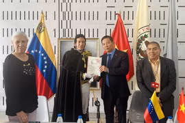 Tiến sỹ Juan Gamez trao tặng ảnh Chủ tịch Hồ Chí Minh do chính ông vẽ cho Đại sứ Việt Nam tại Venezuela Vũ Trung Mỹ. (Ảnh: TTXVN phát)