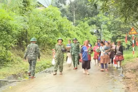 Lực lượng chức năng hỗ trợ người dân huyện Mường Lát (Thanh Hóa) sơ tán đến nơi an toàn. (Ảnh: TTXVN phát)