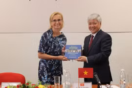 Chủ tịch Ủy ban Trung ương MTTQ Việt Nam Đỗ Văn Chiến trao tặng cuốn sách 'Tình cảm của nhân dân thế giới với Chủ tịch Hồ Chí Minh' được dịch sang tiếng Séc cho Chủ tịch Đảng Cộng sản Séc - Morava Katerina Konecna. (Ảnh: Ngọc Biên/TTXVN)
