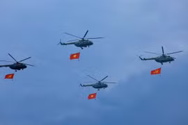 Máy bay trực thăng mang cờ Đảng, cờ Tổ quốc bay qua Lễ đài. (Ảnh: Dương Giang/TTXVN)