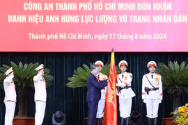 Tổng Bí thư, Chủ tịch nước Tô Lâm gắn Huy hiệu Anh hùng lực lượng vũ trang nhân dân lên lá cờ truyền thống của Công an Thành phố Hồ Chí Minh. (Ảnh: Lâm Khánh/TTXVN)