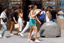 Người dân di chuyển dưới trời nắng nóng tại Madrid, Tây Ban Nha. (Ảnh: AFP/TTXVN)