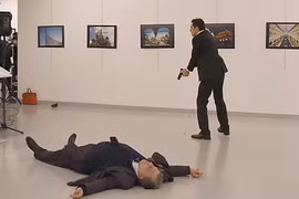 Kẻ tấn công (phía sau) và Đại sứ Nga Andrey Karlov (trước) sau vụ xả súng tại trung tâm nghệ thuật ở Ankara ngày 19/12. (Nguồn: AFP/TTXVN)