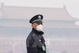 Cảnh sát Trung Quốc đeo khẩu trang tránh khói mù ô nhiễm tại thủ đô Bắc Kinh. (Ảnh: Reuters/TTXVN)