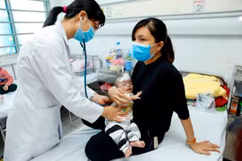 Bác sỹ chăm sóc và điều trị cho trẻ tại Bệnh viện Nhi Trung ương. (Ảnh: Dương Ngọc/TTXVN)