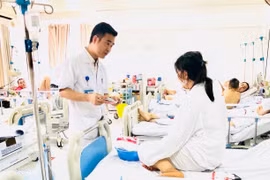 Bác sỹ Vũ Trung Trực, Phó trưởng khoa Phẫu thuật Tạo hình - Thẩm mỹ thăm khám cho bệnh nhân sau 6 ngày phẫu thuật. (Ảnh: PV/Vietnam+)