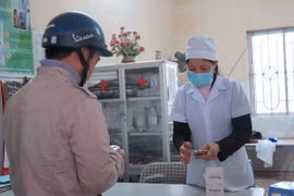 Cấp phát thuốc cho người dân phòng bệnh viên não mô cầu. (Ảnh: TTXVN/Vietnam+)