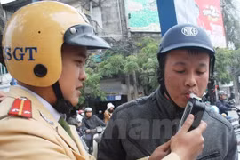 Cảnh sát giao thông tiến hành đo nồng độ cồn của người điều khiển phương tiện. (Ảnh: Việt Hùng/Vietnam+)