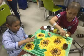 Bệnh nhân ung thư vẽ tranh để trưng bày tại ngày hội. (Ảnh: PV/Vietnam+)