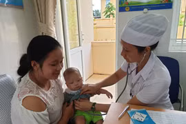 Nhân viên y tế chăm sóc sức khỏe cho trẻ nhỏ. (Ảnh: PV/Vietnam+)