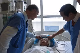 Giáo sư Nguyễn Thanh Liêm thăm khám cho một bệnh nhân sau phẫu thuật. (Ảnh: PV/Vietnam+)