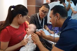 Bác sỹ của tổ chức Facing the world thăm khám cho các em nhỏ dị tật. (Ảnh: TG/Vietnam+)