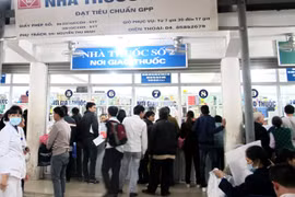 Người dân đứng xếp hàng mua thuốc tại quầy thuốc của Bệnh viện Bạch Mai. (Ảnh: PV/Vietam+)